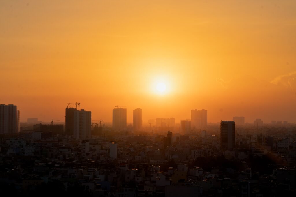 Golden summer sunset over city skyline with high-rise buildings.
